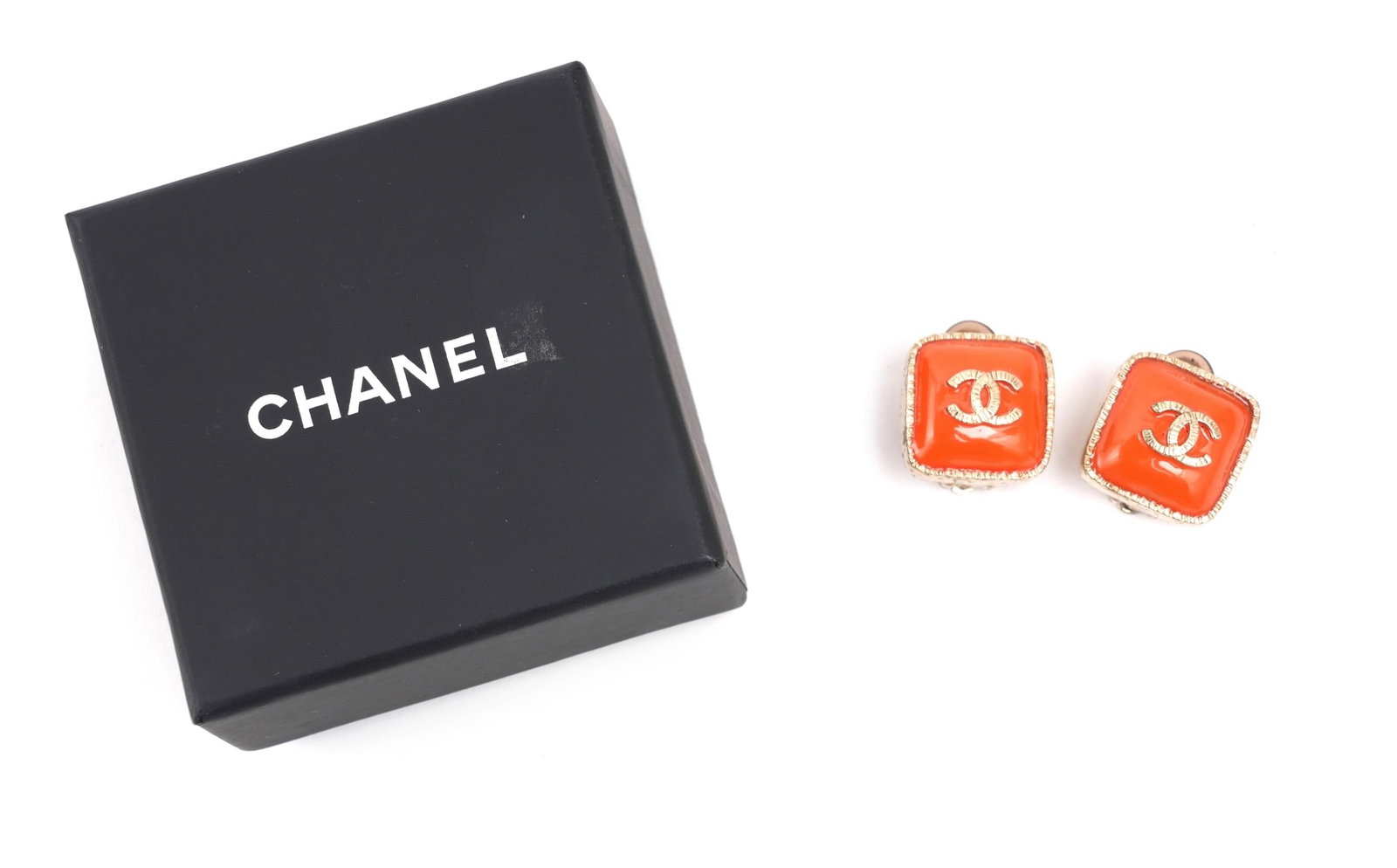 A PAIR OF BOXED CHANEL POURED ORANGE GLASS AND GILT METAL CLIP EARRINGS Made in France, late 20th: A PAIR OF BOXED CHANEL POURED ORANGE GLASS AND GILT METAL CLIP EARRINGS. Made in France, late 20th Century A striking and highly recognisable design from the house of Chanel, each earring formed as a 