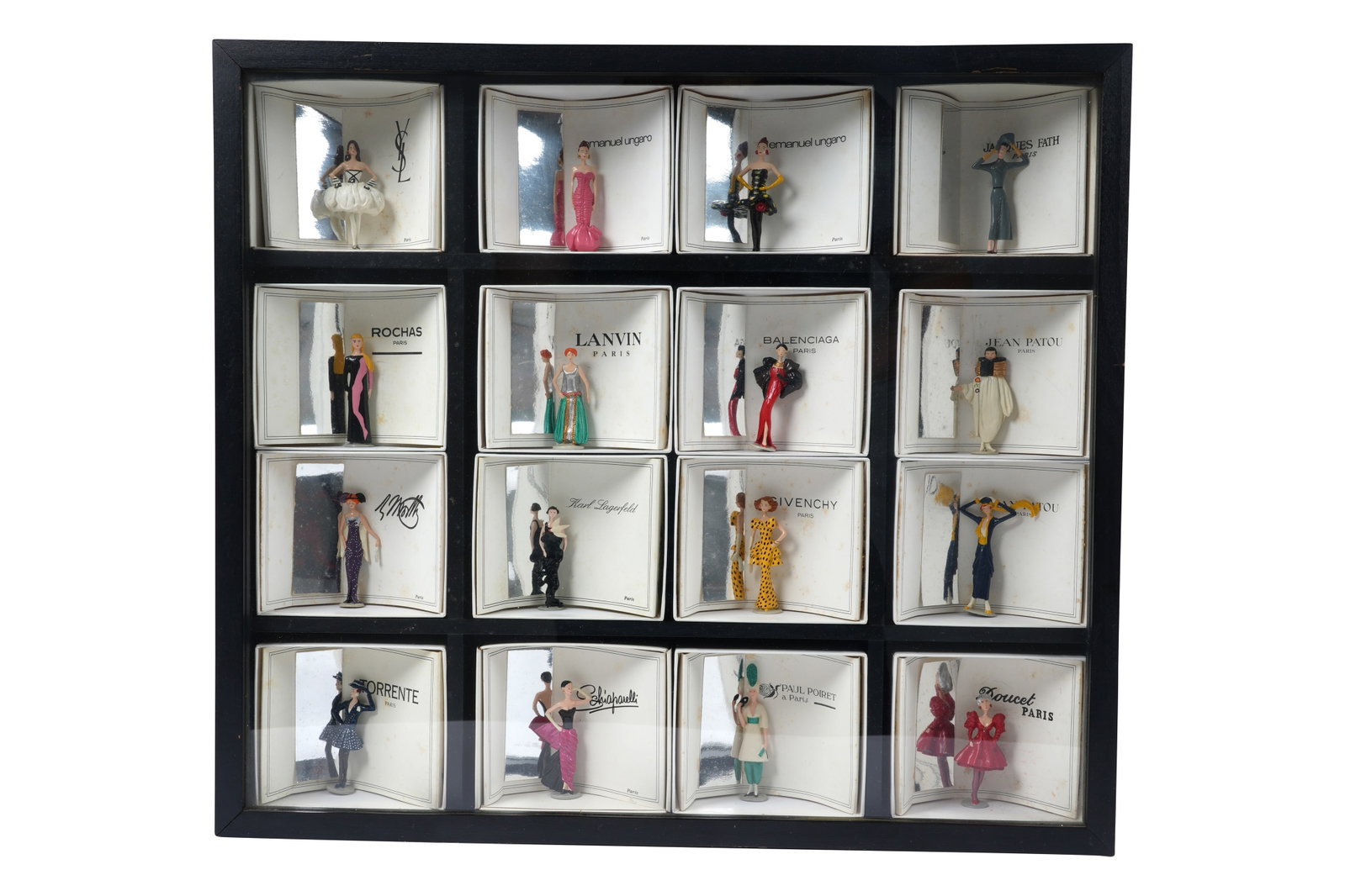 A COLLECTION OF 16 PIXI 'MODE: LA HAUTE COUTURE' MINIATURE FASHION DESIGNER FIGURINES IN DISPLAY: A COLLECTION OF SIXTEEN PIXI 'MODE: LA HAUTE COUTURE' MINIATURE FASHION DESIGNER FIGURINES IN DISPLAY BOX Probably France, c.1980s In 1986, the French creator Pixi released a highly sought-after line 