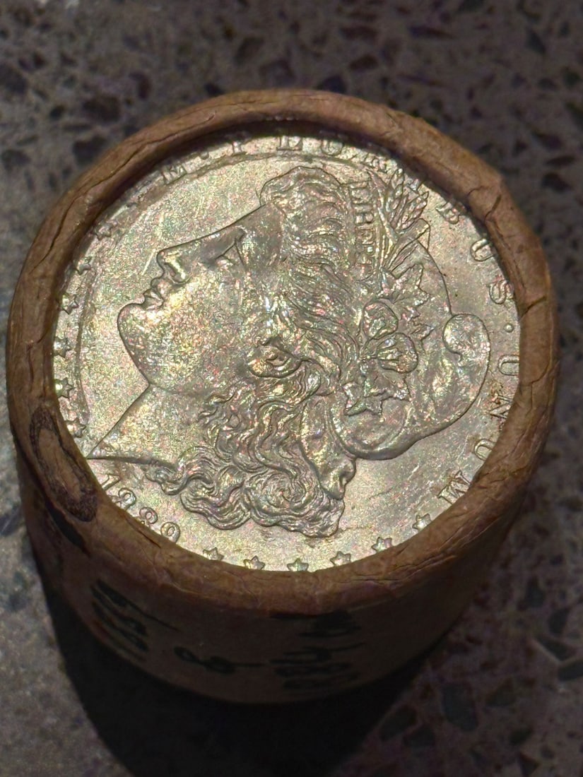 BU $10 Morgan Silver Dollar Roll 1889 & 1884 Ends: An original Brilliant Uncirculated (BU) sealed roll of Morgan Silver Dollars, featuring an 1889 coin on one end and an 1884 coin on the opposite end. The roll remains sealed, with only the front and b