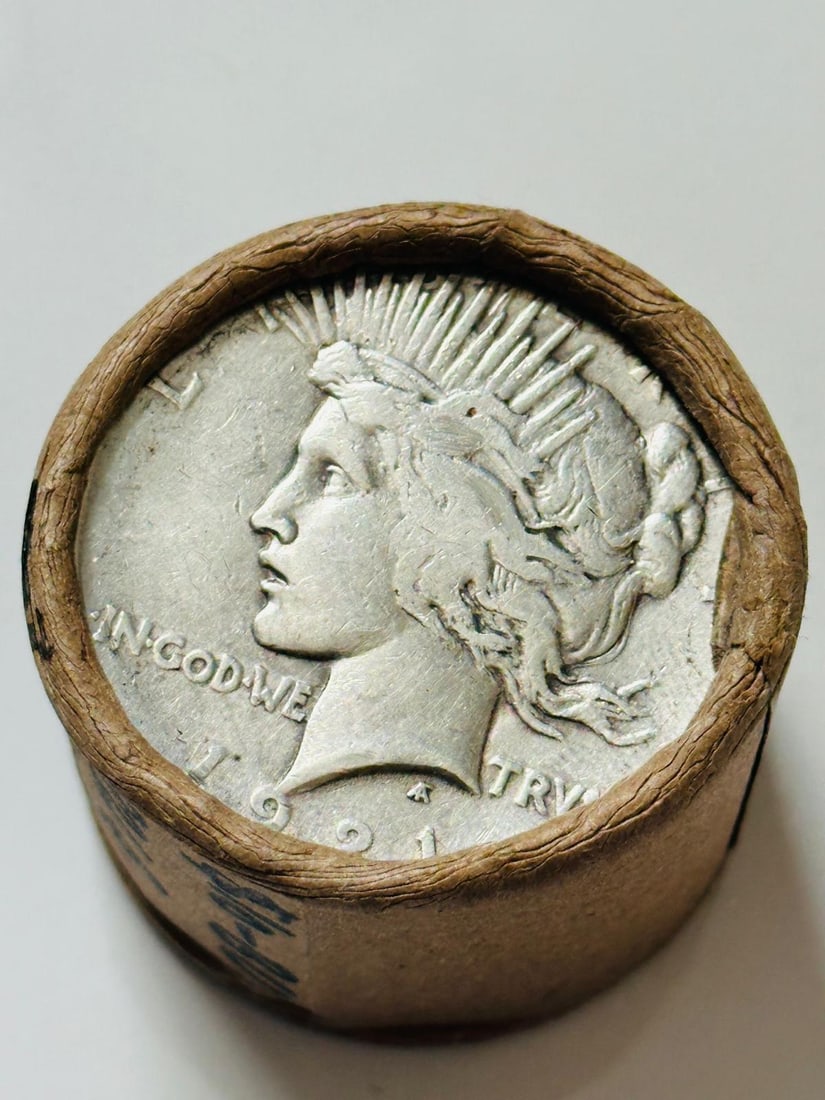 BU $10 Peace Silver Dollar 1921 & 1923 Ends: An original Brilliant Uncirculated (BU) sealed roll containing 10 Peace Silver Dollars, featuring a high-relief 1921 coin on one end and a 1923 coin on the other. The roll remains sealed to ensure the