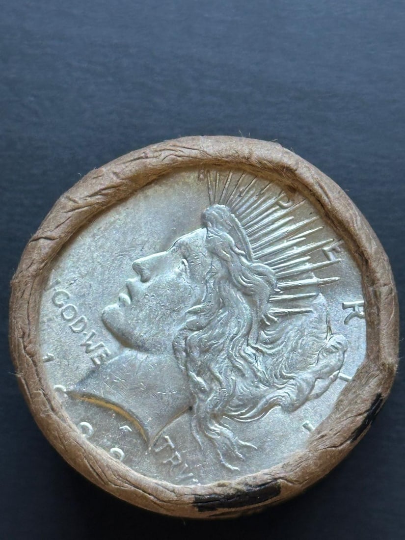 BU $10 Peace Silver Dollar Roll 1922 & 1922 Ends: An original Brilliant Uncirculated (BU) sealed roll containing 10 Peace Silver Dollars, featuring a 1922 coin on both ends. The roll remains sealed with only the end coins visible to ensure the interi