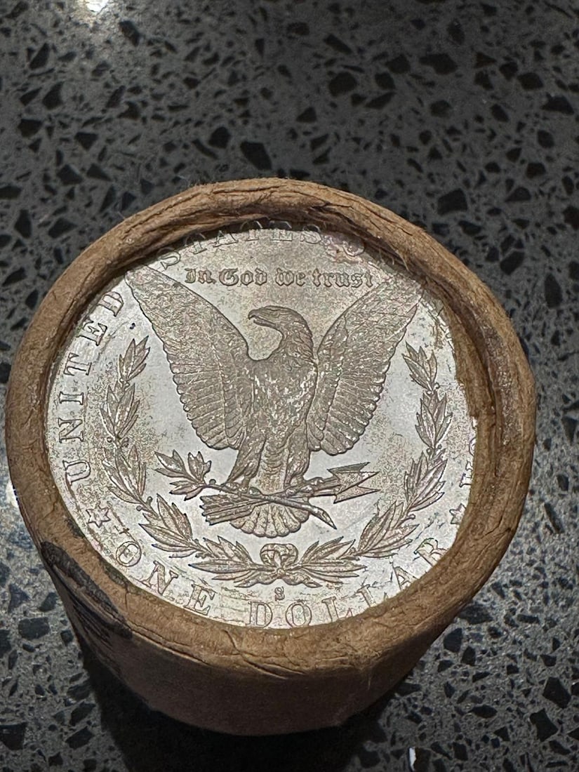 BU $10 Morgan Silver Dollar Roll S & CC Ends: An original Brilliant Uncirculated (BU) sealed roll of Morgan Silver Dollars, featuring a San Francisco (S) Mint coin on one end and a Carson City (CC) Mint coin on the opposite end. The roll remains 