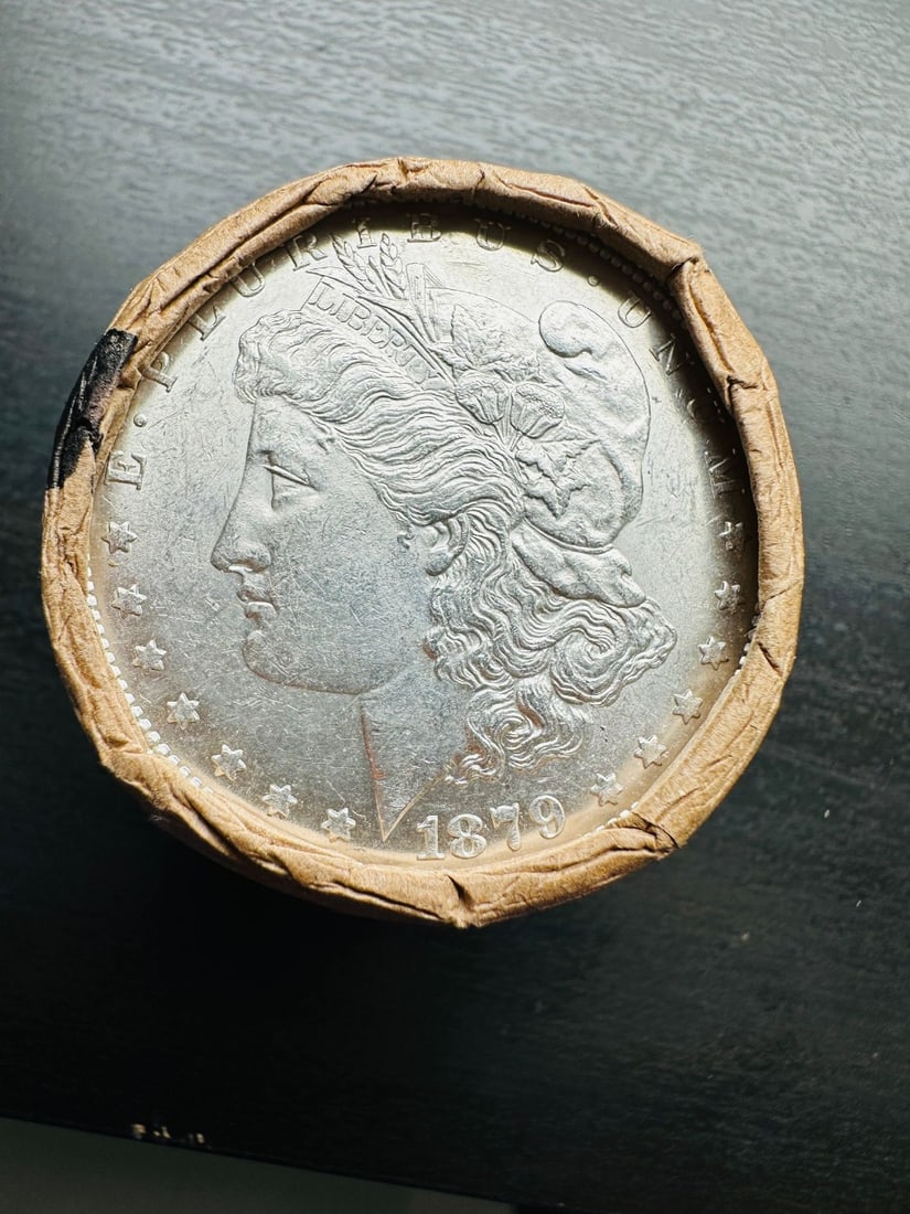 BU $10 Morgan Silver Dollar Roll 1879 & CC Ends: An original Brilliant Uncirculated (BU) sealed roll of Morgan Silver Dollars, featuring an 1879 coin on one end and a Carson City (CC) Mint coin on the opposite end. The roll remains sealed, with only