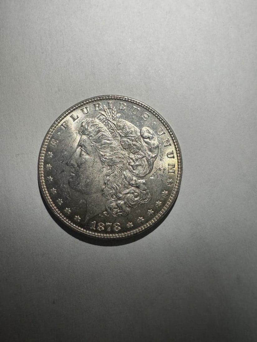 1878- Morgan dollar 7 TF: The 1878 Morgan Dollar with 7 Tail Feathers is a historic early variety from the first year of issue. It reflects a design correction made shortly after initial production. Struck in 90% silver, it co