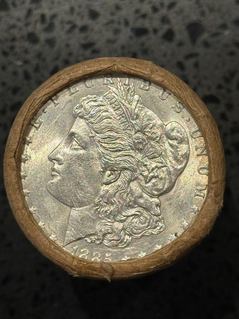 BU $10 Morgan Silver Dollar Roll 1885 & CC Ends: An original Brilliant Uncirculated (BU) sealed roll of Morgan Silver Dollars, featuring an 1885 coin on one end and a Carson City (CC) Mint coin on the opposite end. The roll remains sealed, with only