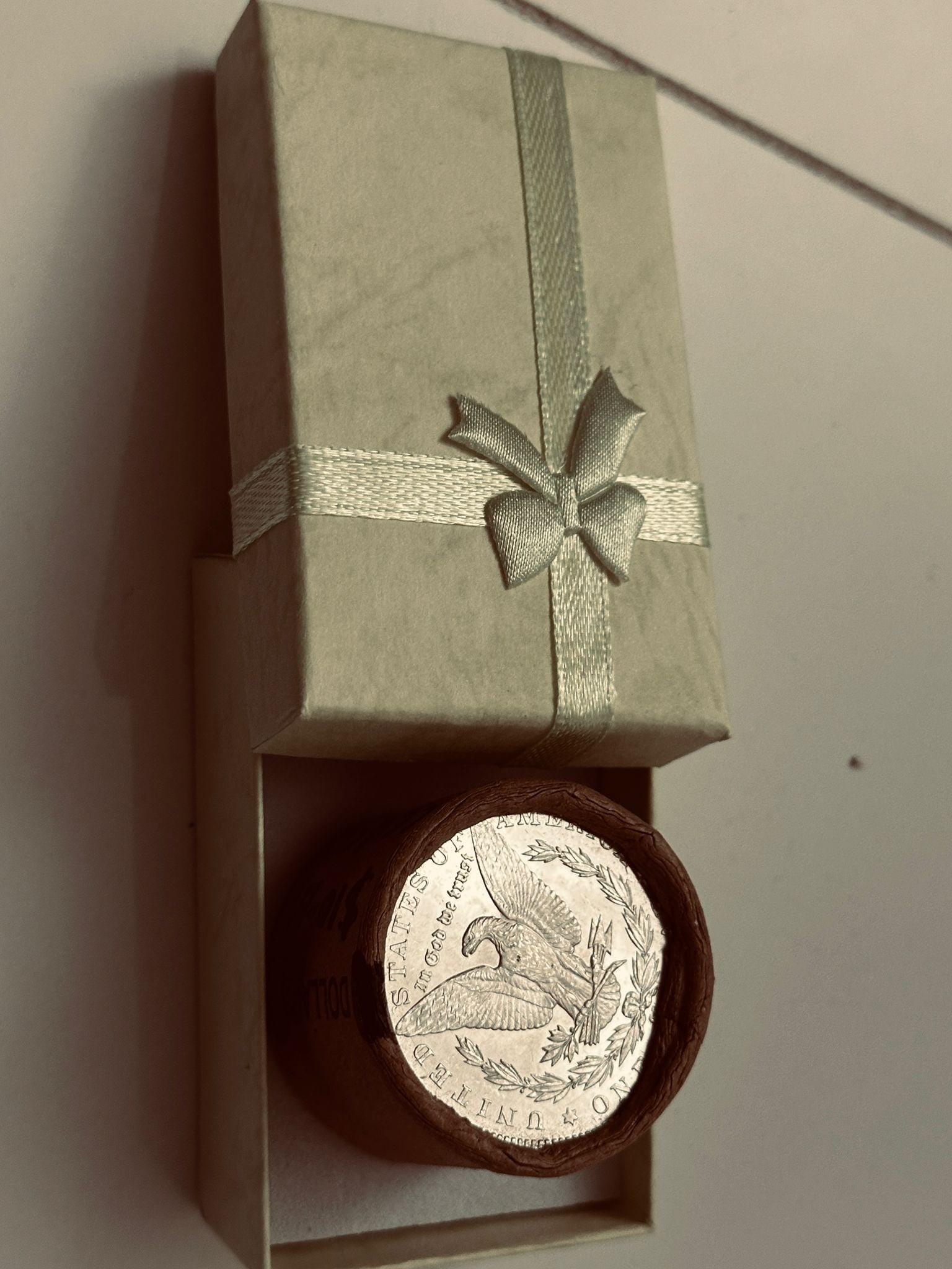 BU $10 Morgan Silver Dollar Roll 1879 & CC Ends: An original Brilliant Uncirculated (BU) sealed roll of Morgan Silver Dollars, featuring an 1879 coin on one end and a Carson City (CC) Mint coin on the opposite end. The roll remains sealed, with only