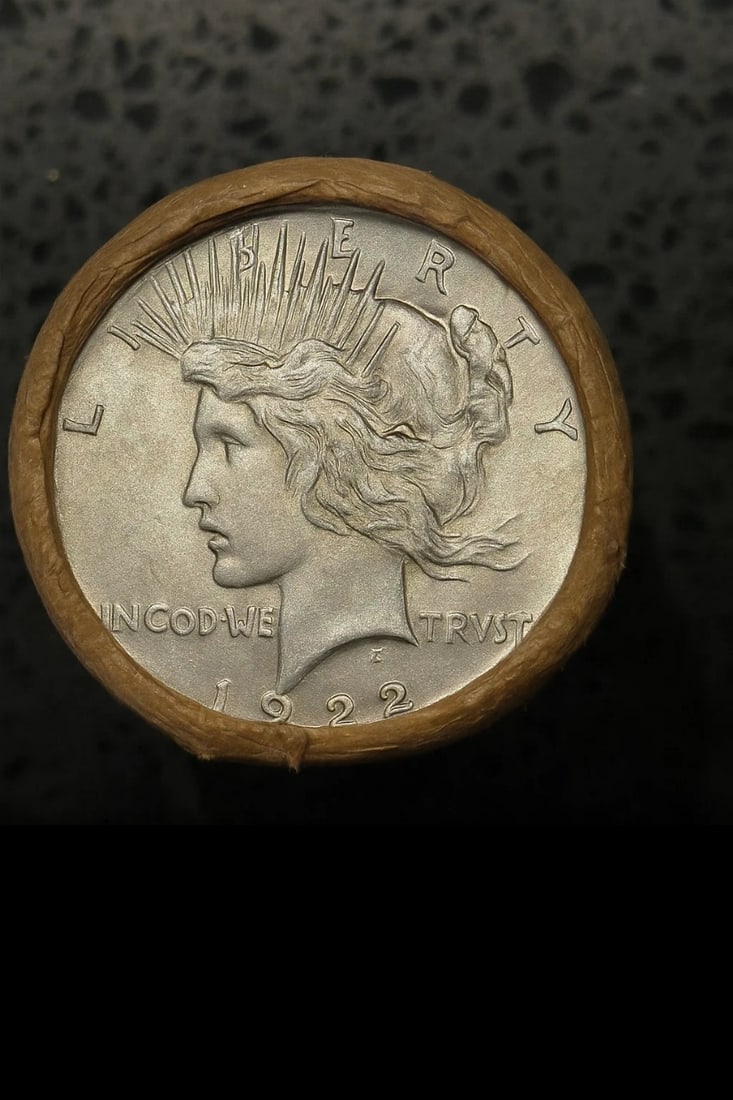 BU $10 Peace Silver Dollar Roll 1922 & 1922 Ends: An original Brilliant Uncirculated (BU) sealed roll containing 10 Peace Silver Dollars, featuring a 1922 coin on both ends. The roll remains sealed with only the end coins visible to ensure the interi