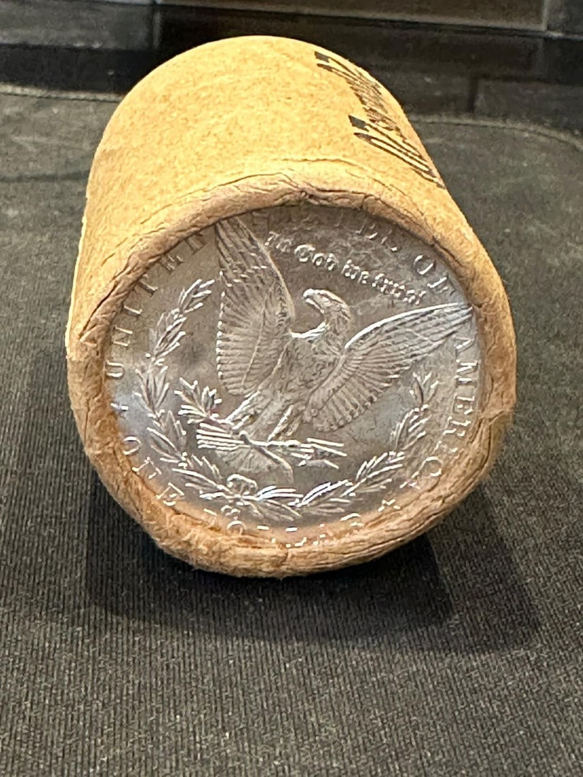 BU $10 Morgan Silver Dollar Roll CC & S Ends: An original Brilliant Uncirculated (BU) sealed roll of Morgan Silver Dollars, featuring a Carson City (CC) Mint coin on one end and a San Francisco (S) Mint coin on the opposite end. The roll remains 