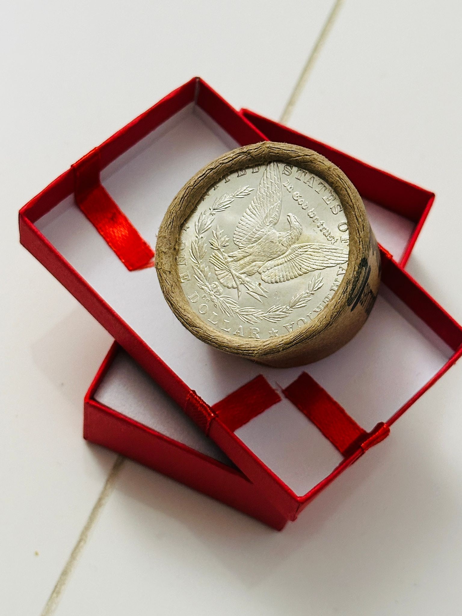 BU $10 Morgan Silver Dollar Roll CC & CC Ends: An original Brilliant Uncirculated (BU) sealed roll of Morgan Silver Dollars, featuring a Carson City (CC) Mint coin on both ends. The roll remains sealed, with only the front and back coins visible. 