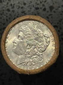 BU $10 Morgan Silver Dollar Roll 1885 & CC Ends: An original Brilliant Uncirculated (BU) sealed roll of Morgan Silver Dollars, featuring an 1885 coin on one end and a Carson City (CC) Mint coin on the opposite end. The roll remains sealed, with only