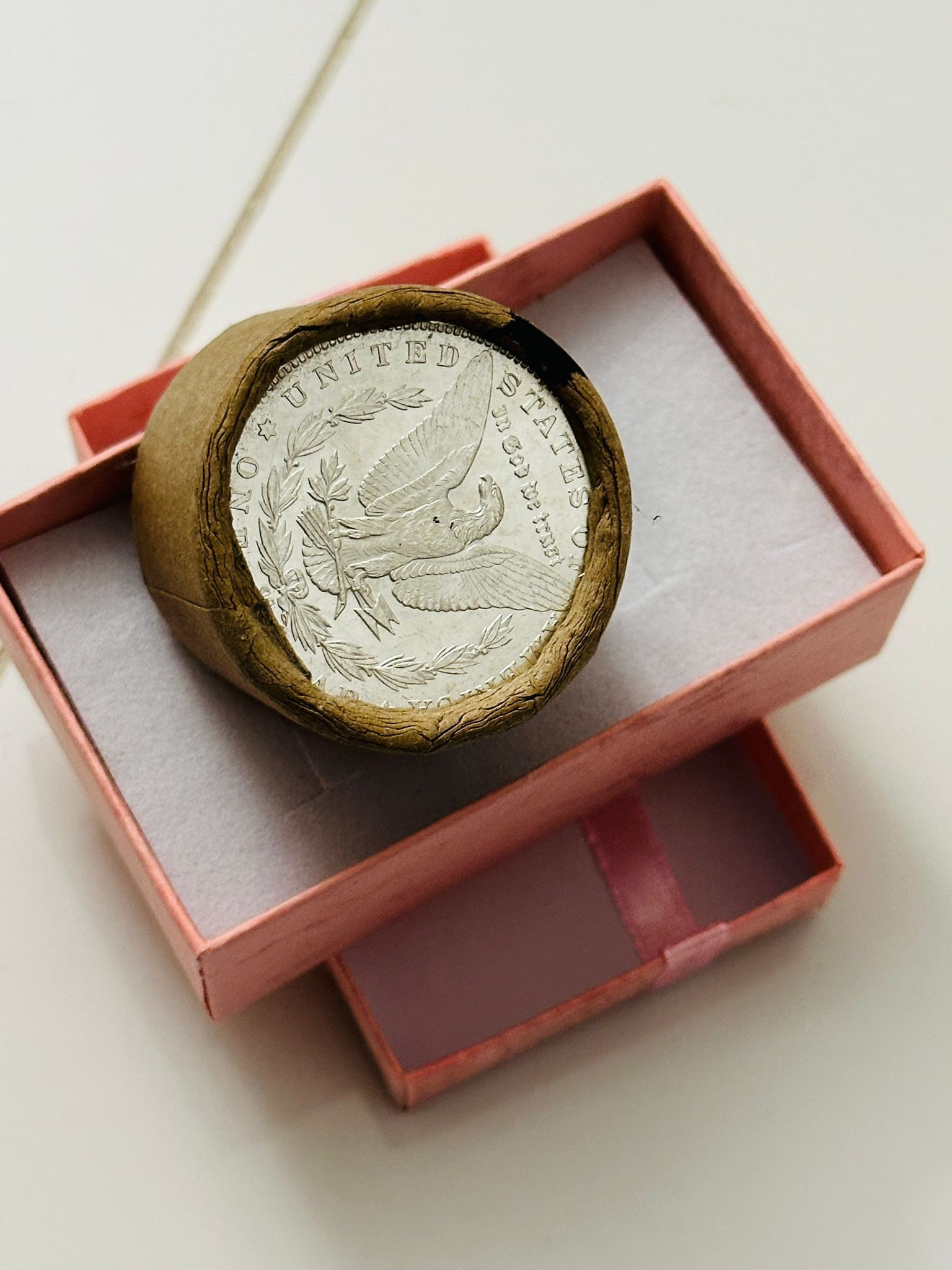 BU $10 Morgan Silver Dollar Roll 1889 & CC Ends: An original Brilliant Uncirculated (BU) sealed roll of Morgan Silver Dollars, featuring an 1889 coin on one end and a Carson City (CC) Mint coin on the opposite end. The roll remains sealed, with only