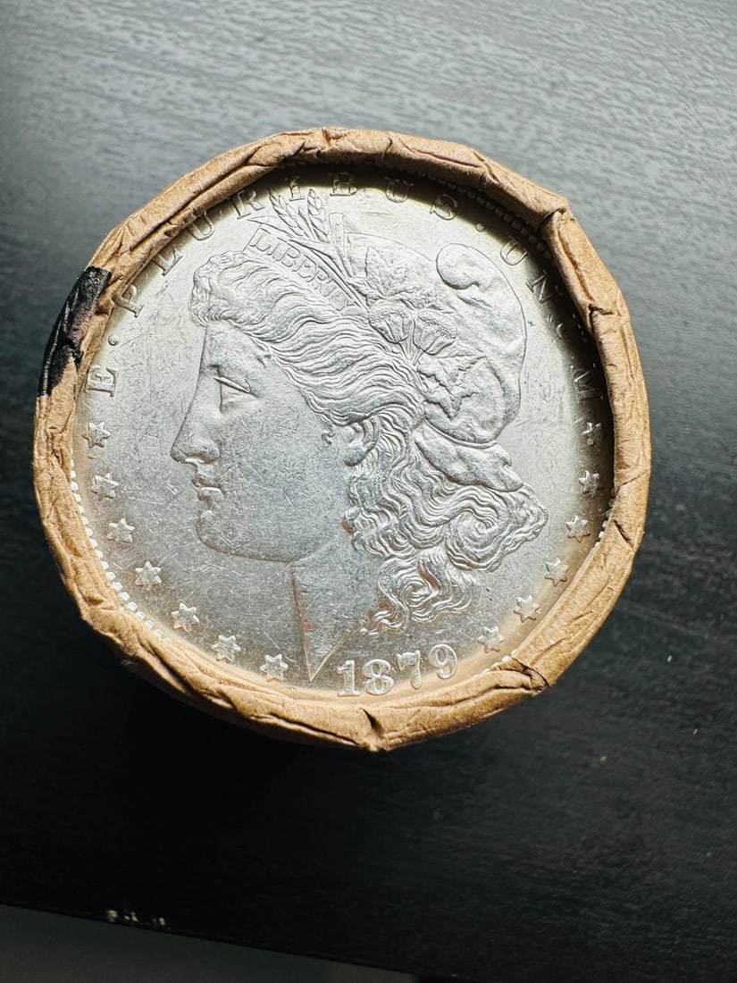 BU $10 Morgan Silver Dollar Roll 1879 & CC Ends: An original Brilliant Uncirculated (BU) sealed roll of Morgan Silver Dollars, featuring an 1879 coin on one end and a Carson City (CC) Mint coin on the opposite end. The roll remains sealed, with only