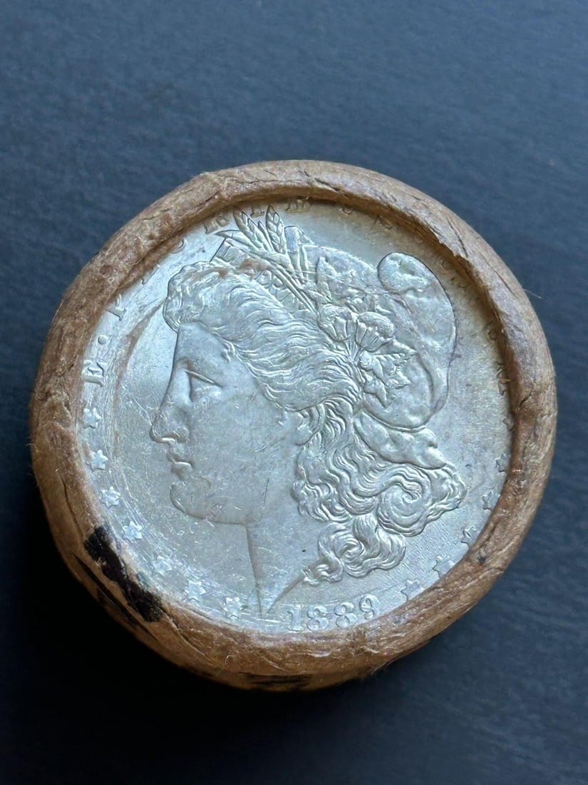 BU $20 Morgan Silver Dollar Roll 1889 & CC Ends: An original Brilliant Uncirculated (BU) sealed roll of Morgan Silver Dollars, featuring an 1889-dated coin on one end and a Carson City (CC) Mint coin on the opposite end. The roll remains sealed with