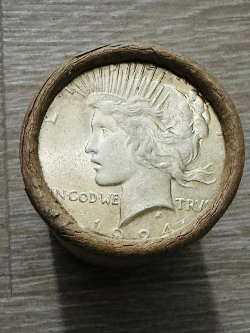 $20 - Peace Silver Dollar Roll 1924 & 1928 Ends: An original Brilliant Uncirculated (BU) sealed roll of Peace Silver Dollars, featuring a 1924 coin on one end and a 1928 coin on the opposite end. The roll remains sealed with only the end coins visib