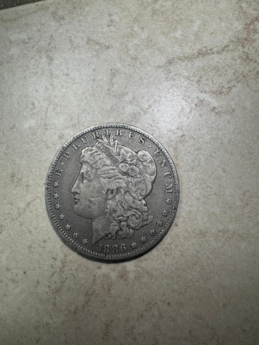 1886-O Morgan Dollar VF30 (Non-Graded): A circulated 1886-O Morgan Silver Dollar struck at the New Orleans Mint in 90% silver. Graded approximately Very Fine (VF30), this example shows moderate wear with clear major details and strong overa
