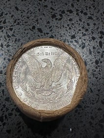 BU $10 Morgan Silver Dollar Roll S & CC Ends: An original Brilliant Uncirculated (BU) sealed roll of Morgan Silver Dollars, featuring a San Francisco (S) Mint coin on one end and a Carson City (CC) Mint coin on the opposite end. The roll remains 
