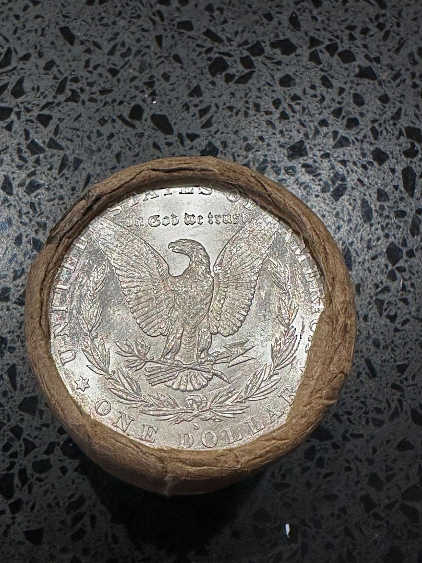 BU $10 Morgan Silver Dollar Roll S & CC Ends: An original Brilliant Uncirculated (BU) sealed roll of Morgan Silver Dollars, featuring a San Francisco (S) Mint coin on one end and a Carson City (CC) Mint coin on the opposite end. The roll remains 