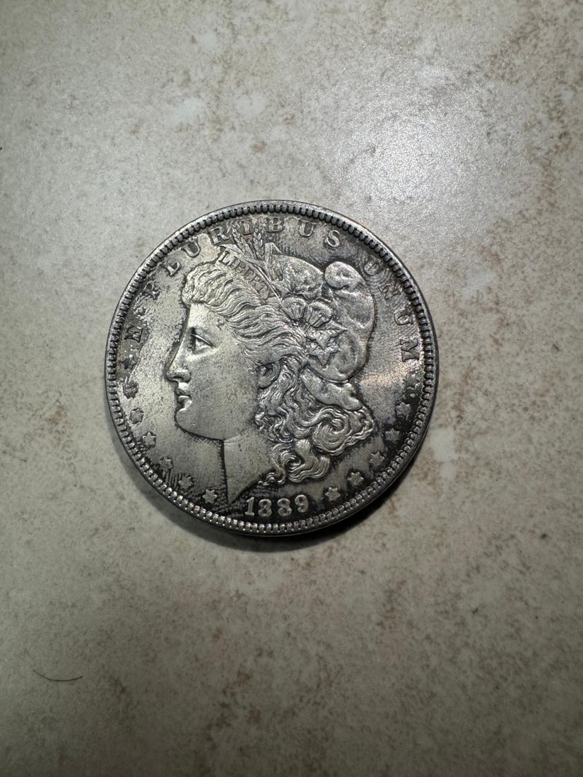 1889 Morgan Dollar AU53 (Non-Graded): The 1889 Morgan Dollar AU53 (Non-Graded) displays light wear with strong detail and traces of mint luster, making it a desirable near-uncirculated example.