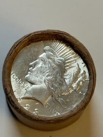 BU $10 Peace Silver Dollar Roll 1925 & 1923 Ends: An original Brilliant Uncirculated (BU) sealed roll containing 10 Peace Silver Dollars, featuring a 1925 coin on one end and a 1923 coin on the other. The roll remains sealed to ensure the interior co
