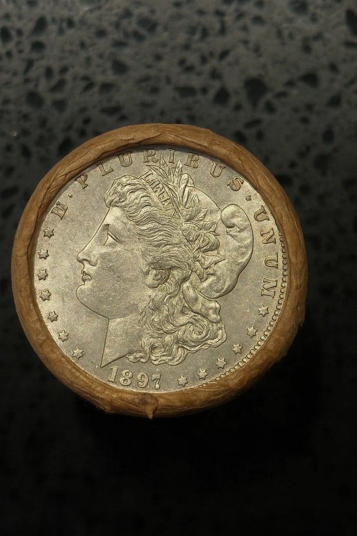 BU $10 Morgan Silver Dollar Roll 1897 & 1897 Ends: An original Brilliant Uncirculated (BU) sealed roll of Morgan Silver Dollars, featuring an 1897 coin on one end and an 1897 coin on the opposite end. The roll remains sealed, with only the front and b