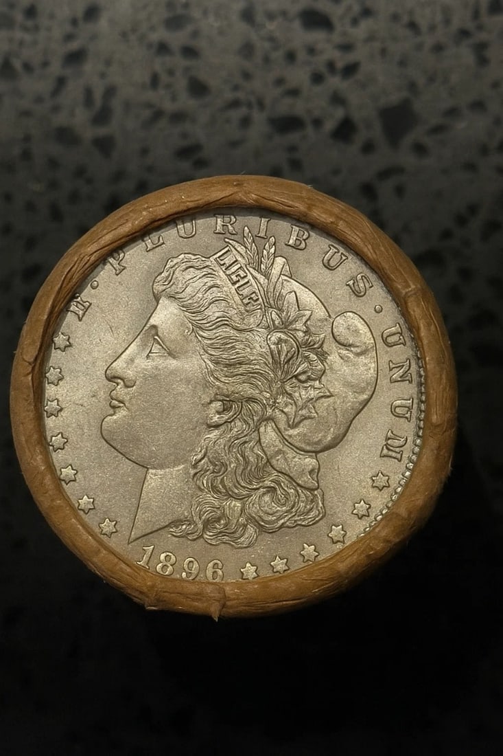 BU $10 Morgan Silver Dollar Roll 1896 & O Ends: An original Brilliant Uncirculated (BU) sealed roll of Morgan Silver Dollars, featuring an 1896 coin on one end and a New Orleans (O) Mint coin on the opposite end. The roll remains sealed, with only 