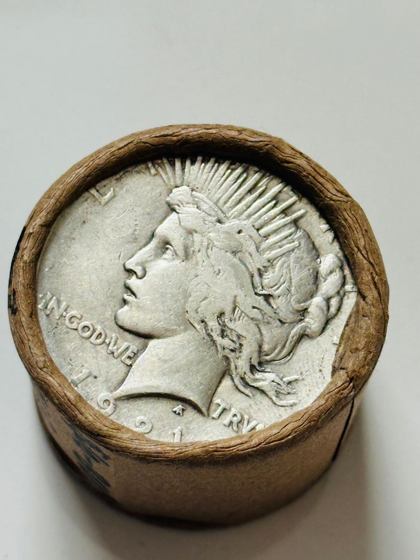 BU $10 Peace Silver Dollar 1921 & 1923 Ends: An original Brilliant Uncirculated (BU) sealed roll containing 10 Peace Silver Dollars, featuring a high-relief 1921 coin on one end and a 1923 coin on the other. The roll remains sealed to ensure the
