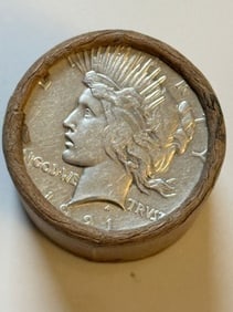 BU $10 Peace Silver Dollar 1921 & 1923 Ends: An original Brilliant Uncirculated (BU) sealed roll containing 10 Peace Silver Dollars, featuring a high-relief 1921 coin on one end and a 1923 coin on the other. The roll remains sealed to ensure the