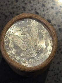 BU $20 Morgan Silver Dollar Roll S & O Ends: An original Brilliant Uncirculated (BU) sealed roll of Morgan Silver Dollars, featuring a San Francisco (S) Mint coin on one end and a New Orleans (O) Mint coin on the opposite end. The roll remains s
