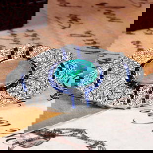 18K White Gold 1.80 Ct. Black Opal Sapphire and Diamond Art Deco Style Brooch: Brooch InformationStyle: Art DecoMetal: 18K White Gold Width: 45 mm.Length: 24 mm.Weight: 11.05 g. (approx. in total)Center Gemstones Type: Black OpalShape: Oval CabochonSize: 14 x 10 mm.