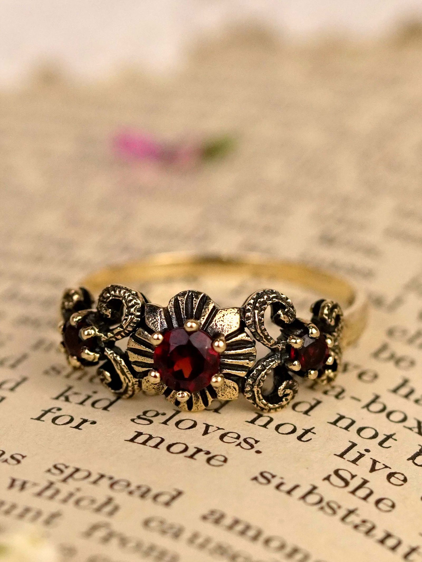 9K Yellow Gold Natural Garnet Vintage Style Three Stone Ring: CHARACTERISTICSOrigin: ThailandMetal: Solid 9K Yellow GoldRing Size: US 7Total Gemstones Weight: 0.50 carat. (approx.)Total Gram Weight: 1.89 g. (approx.)*Pictures have been enlarged to show details*P