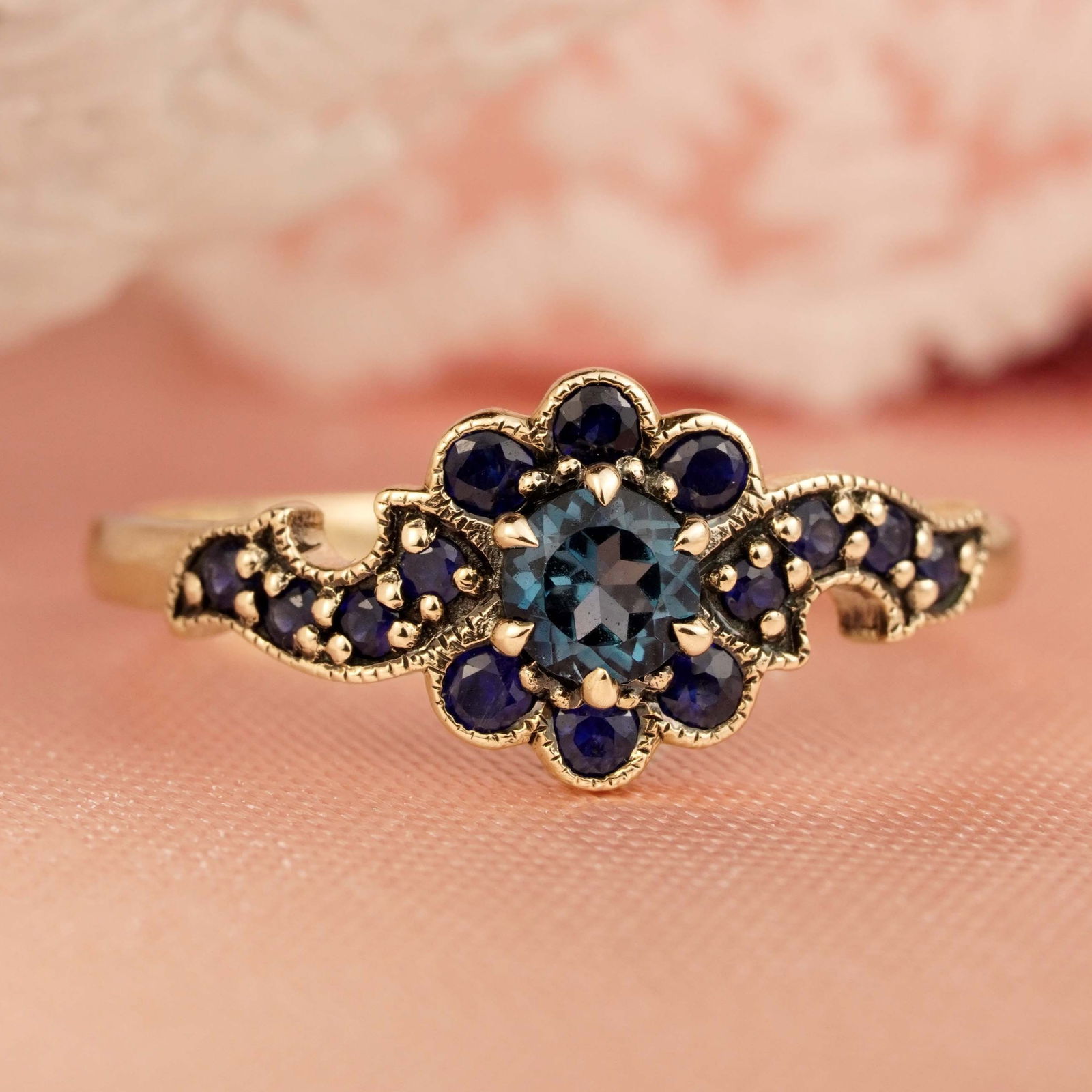 9K Yellow Gold Natural London Blue Topaz and Sapphire Vintage Style Floral Ring: CHARACTERISTICSOrigin: ThailandMetal: Solid 9K Yellow GoldRing Size: US 7Total Gemstones Weight: 0.75 carat. (approx.)Total Gram Weight: 1.61 g. (approx.)*Pictures have been enlarged to show details*P