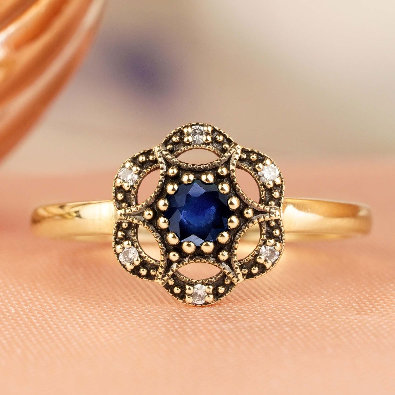 9K Yellow Gold Natural Blue Sapphire and Diamond Vintage Style Floral Ring: CHARACTERISTICSOrigin: ThailandMetal: Solid 9K Yellow GoldRing Size: US 7Total Gemstones Weight: 0.285 carat. (approx.)Total Gram Weight: 1.52 g. (approx.)*Pictures have been enlarged to show details*