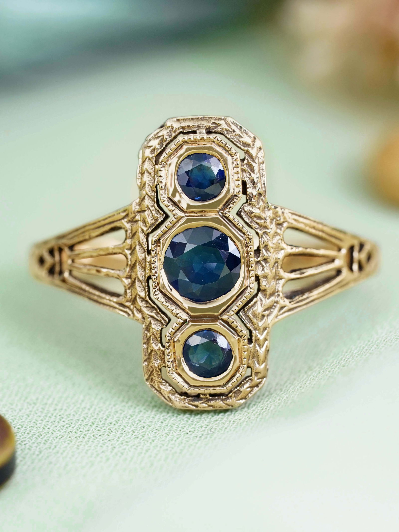 14K Yellow Gold Natural Blue Sapphire Vintage Style Filigree Three Stone Ring: CHARACTERISTICSOrigin: ThailandMetal: Solid 14K Yellow GoldRing Size: US 7Total Gemstones Weight: 0.75 carat. (approx.)Total Gram Weight: 3.64 g. (approx.)*Pictures have been enlarged to show details*