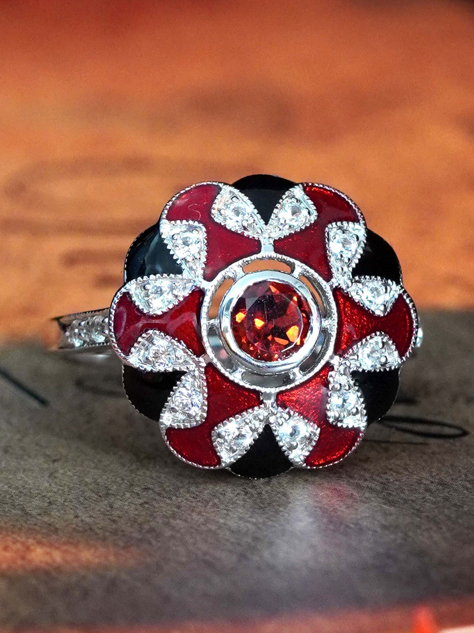 9K White Gold Natural Garnet White Sapphire and Enamel Art Deco Style Halo Ring: Ring InformationStyle: Art-decoMetal: 9K White GoldTotal weight: 5.22 g. (approx. total weight)Size: US 7Center Gemstones Type: GarnetShape: RoundSize: 5 mm. Number: 1Weight: 0.62 Cara