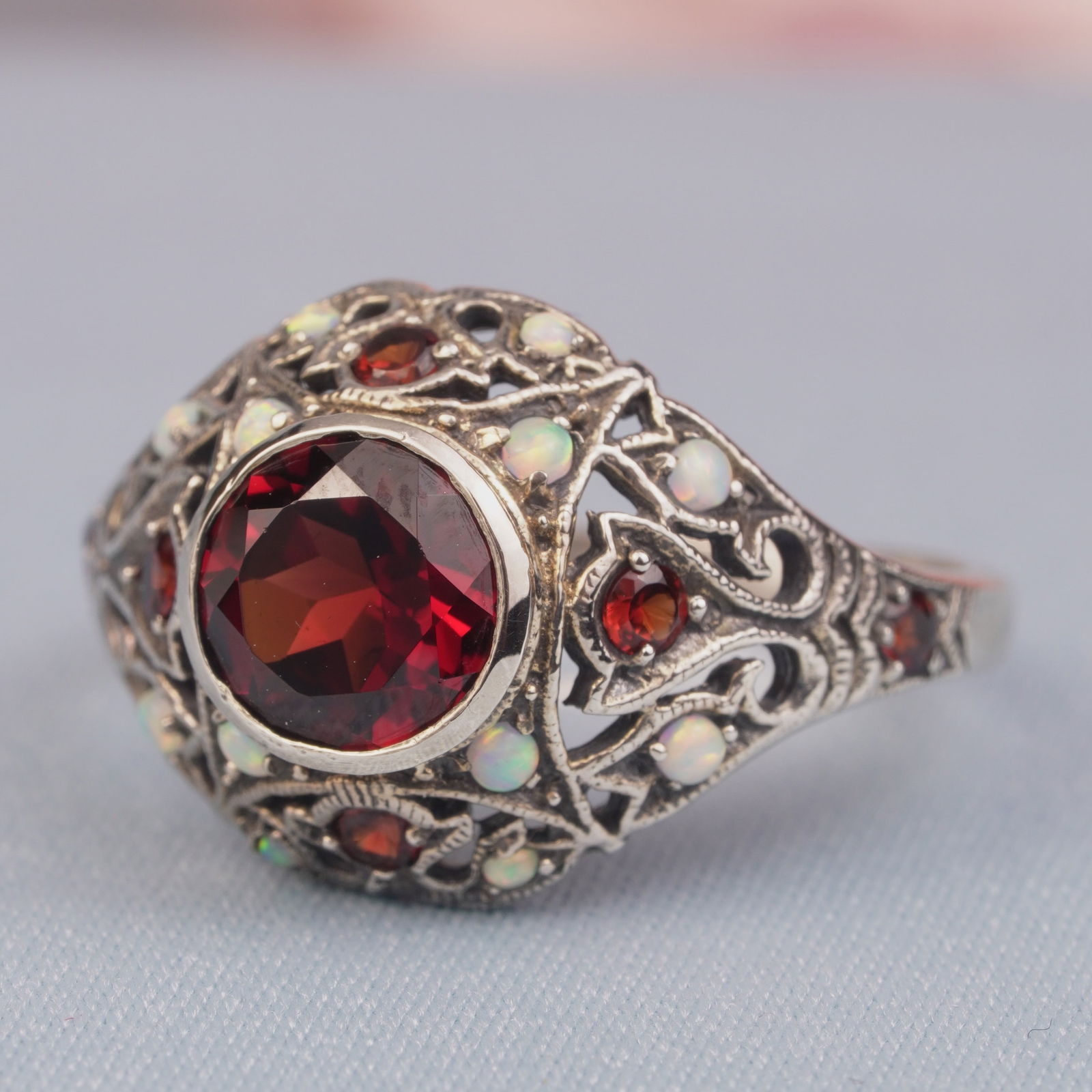 Silver925 Natural Garnet Synthetic Opal White Vintage Filigree Ring: CHARACTERISTICSStatus: In stockOrigin: ThailandMetal: Silver 925Ring Size: US 8Total Gemstones Weight: 0.94 carat. (approx.)Total Gram Weight: 3.15 g. (approx.)*Pictures have been enlarged to show det