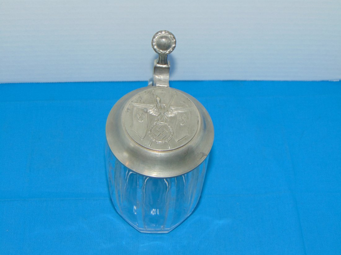 WWII German 0.5L Lidded Stein, Third Reich Embossed Lid: NICE WWII GERMAN BEER STEIN, NICE GRAPHICS TO THE LID, ETCHED .05L MARKING AND A MOLDED CROWN TO THE BOTTOM.