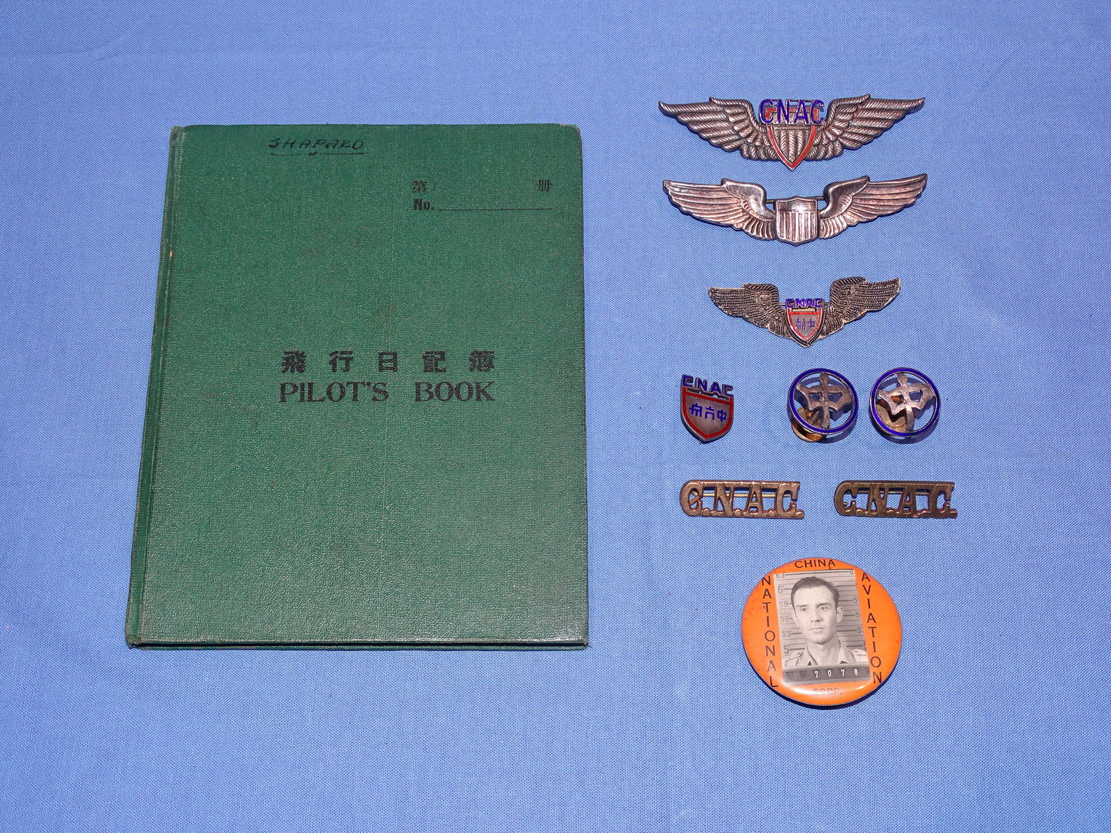 WWII Flying Tigers AVG CNAC Insignia, Wing, Log Book of VAN SHAPARD, Ex. Larry Pistole: SUPERB GROUPING OF RARE WWII CNAC PILOTS INSIGNIA BELONGING TO AVG & CNAC PILOT VAN SHAPARD, EVERY PIECE BEING FROM THE COLLECTION OF LARRY PISTOLE AND ALL PICTURED IN HIS BOOK. THE GROUPING INCLUDES 