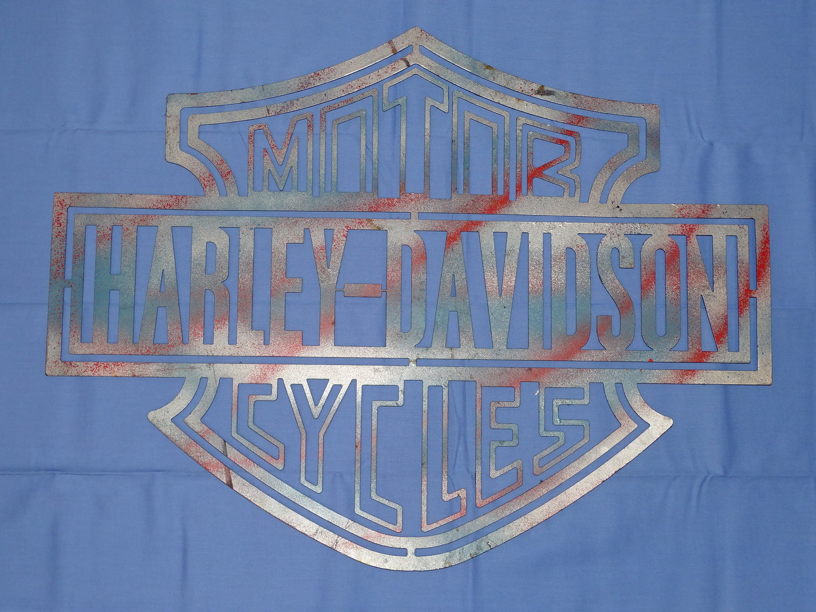 Steel HARLEY - DAVIDSON MotorCycles Logo Sign, 18"x24": STEEL H-D SIGN, LOOKS TO HAVE BEEN PAINTED IN A SILVER / RED / BLUE SCHEME, BLACK TO THE BACK. IT MEASURES 24" WIDE AND 18" TALL.