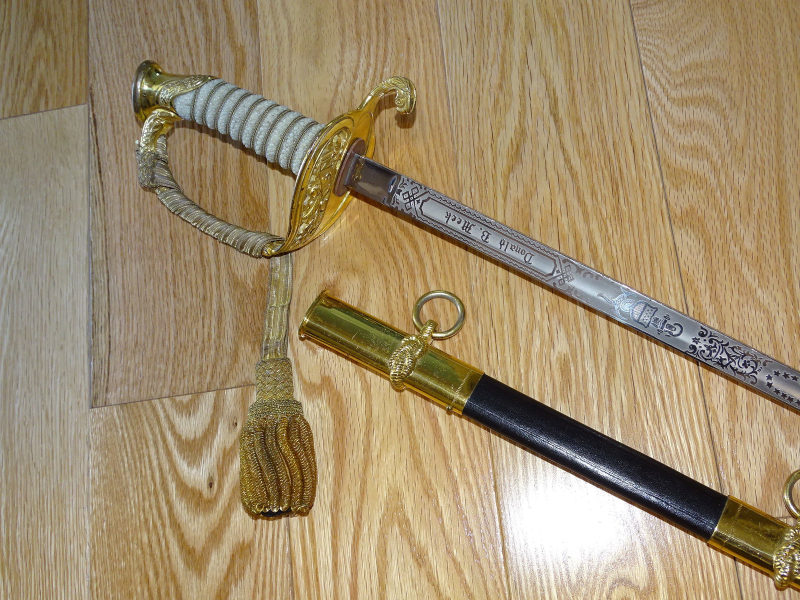 USN Navy Officer's Dress Sword, Triple Engraved & Named, Mfg by Japan Sword: NICE USN OFFICER'S DRESS SWORD, TRIPLE ENGRAVED AND NAMED, SOME MINOR FINISH LOSS NEAR THE TIP OF THE BLADE. VERY NICE GENUINE STING RAY (SAME') GRIP WRAP. MAKER MARKED TO JAPAN SWORD. IT MEASURES APP