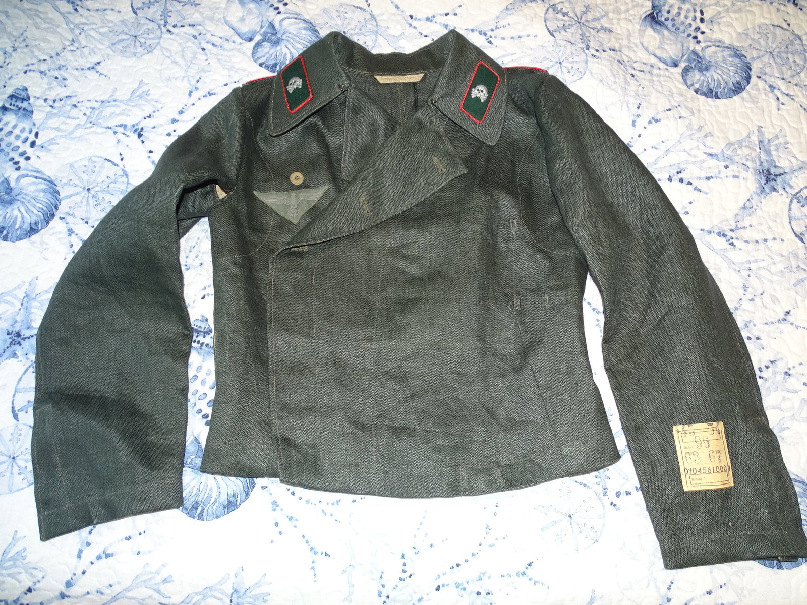 WWII German HBT Panzer Artillery Wrapper Uniform Tunic, Unissued w/ Paper Label: WWII GERMAN HERRINGBONE TWILL GREEN WRAPPER WITH ARMY PANZER ARTILLERY INSIGNIA. SLEEVE HAS PAPER MAKERS / SIZE TAG SEWN TO LEFT SLEEVE WITH SAME EXACT MARKINGS INKED INSIDE, AS WELL AS TWICE NUMBER 7