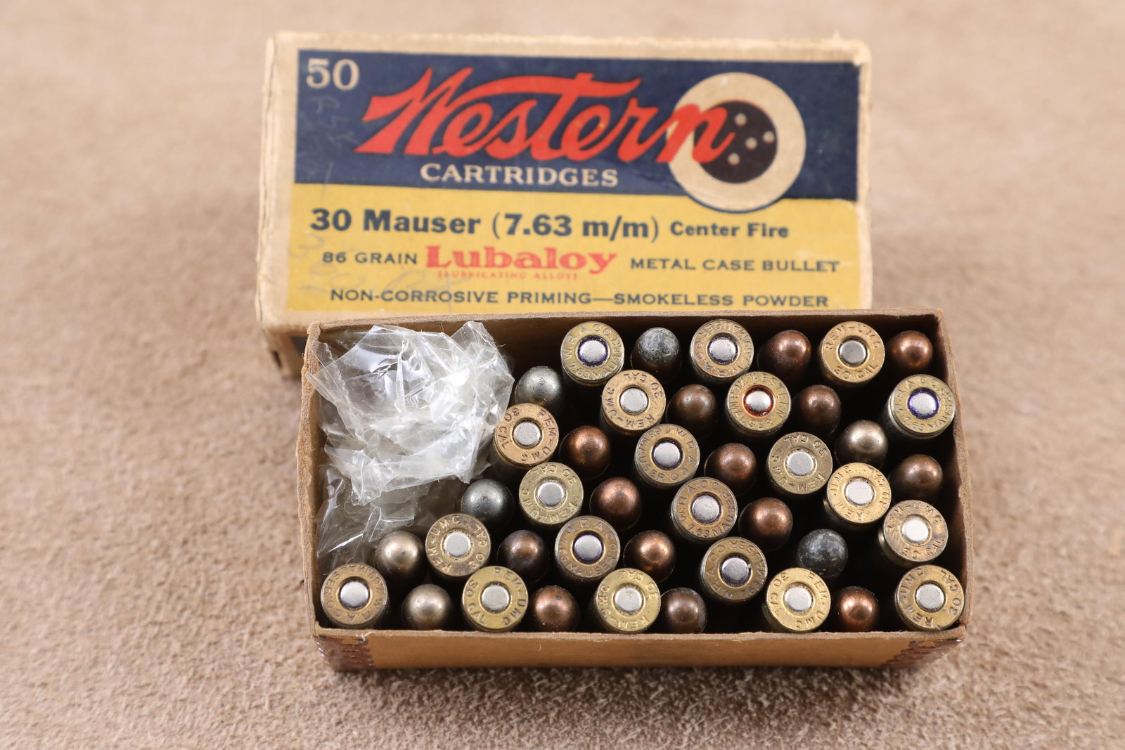 Partial Western Box, 42 Mixed Rounds of Vintage 1930s Winchester and Remington-UMC .30 Mauser Ammo: Good Condition. Missing right hand end flap. Tape repair to left hand end flap. Western "bullet target" label.
