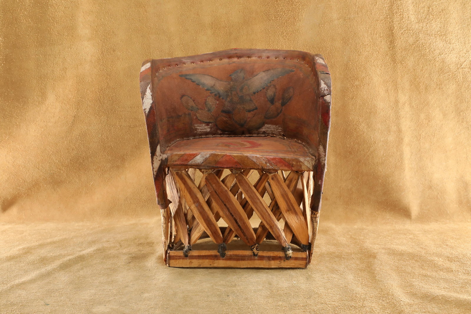 Vintage 20th Century Native American Inspired Thunderbird & Chief Painted Leather & Wood Kid's Chair: Good Condition. Some cracking to the interior back bottom edge of the wood frame. Moderate overall fragility, especially to the nailed and tied bottoms of the wooden support crisscrossing beams. Featu