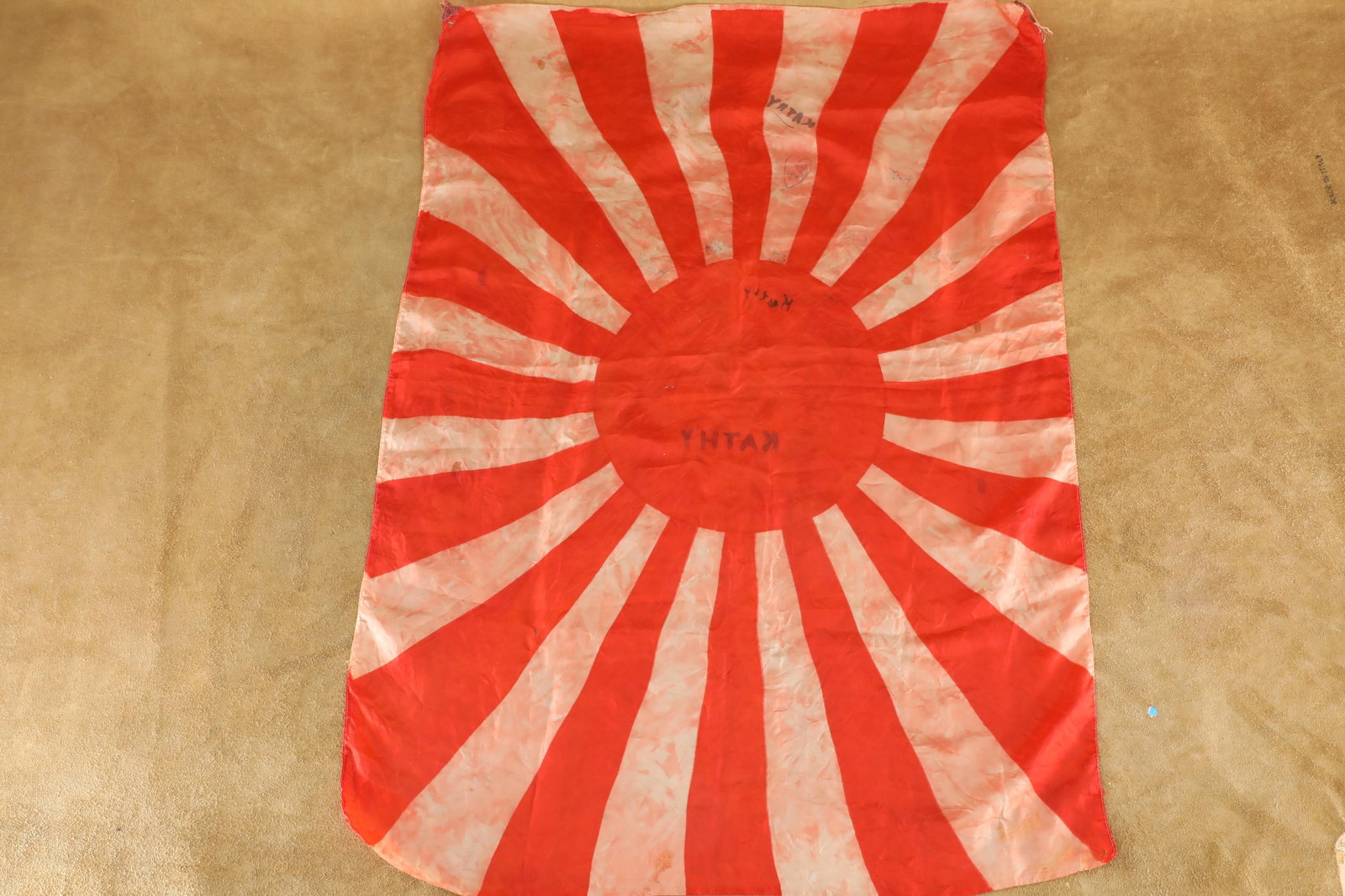 Imperial Japanese Army WWII Silk 36.5" x 26.5" Rays & Rising Sun "Meatball" Flag: Fair Condition. Several scattered small holes in the corners and edges. Moderate overall wrinkling and "bleeding" of the red fields into the white. The name "KATHY" is hand marked 11 times in some fas