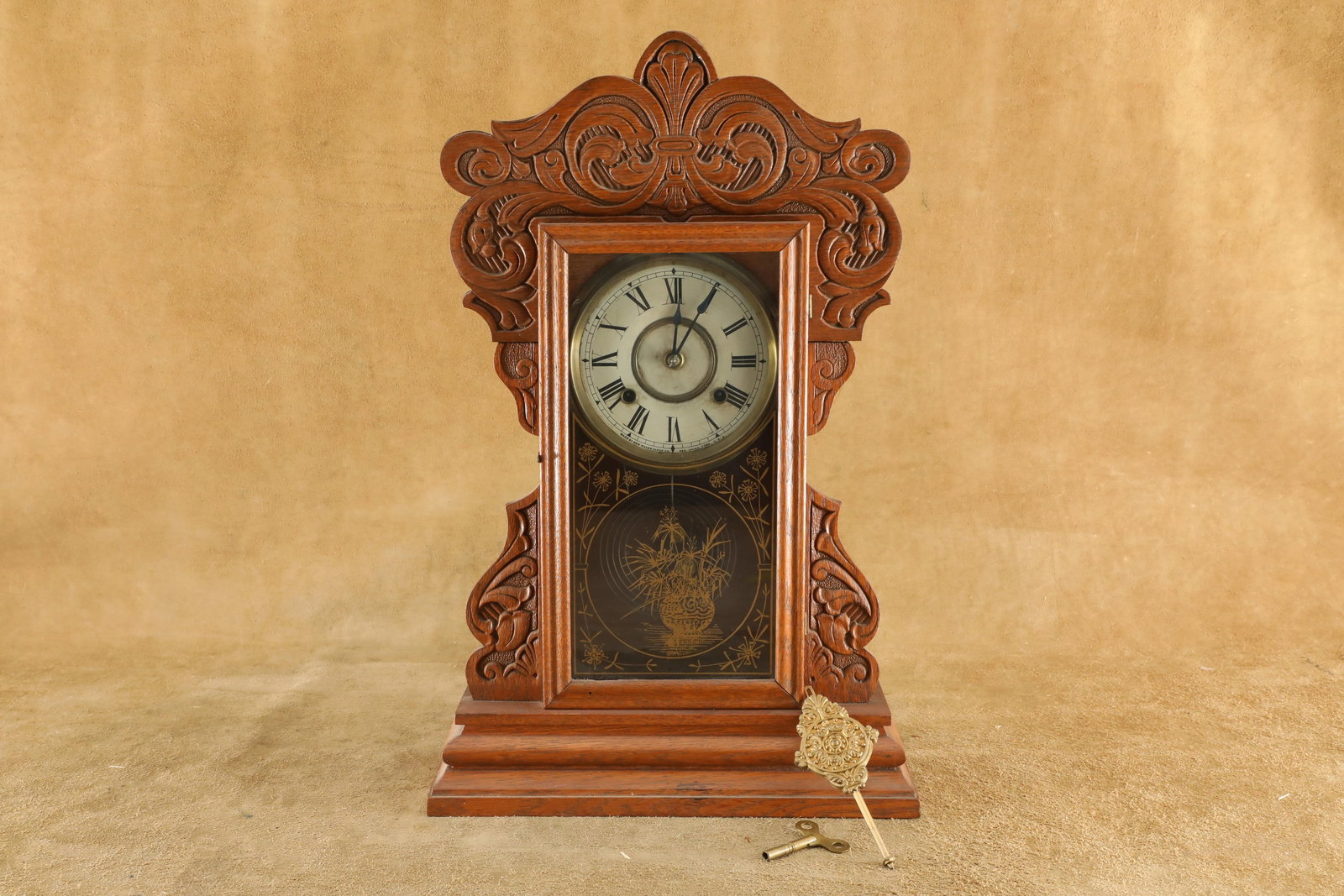 Antique New Haven 8 Day Gingerbread Mantle Clock, 21 3/4 x 13 3/4 x 5: Good to Very Good Condition. Missing the back brace for the top of the case as well as a small chip on the back. This clock comes with its winding key. The face is marked “MADE BY NEW HAVEN CLOCK CO