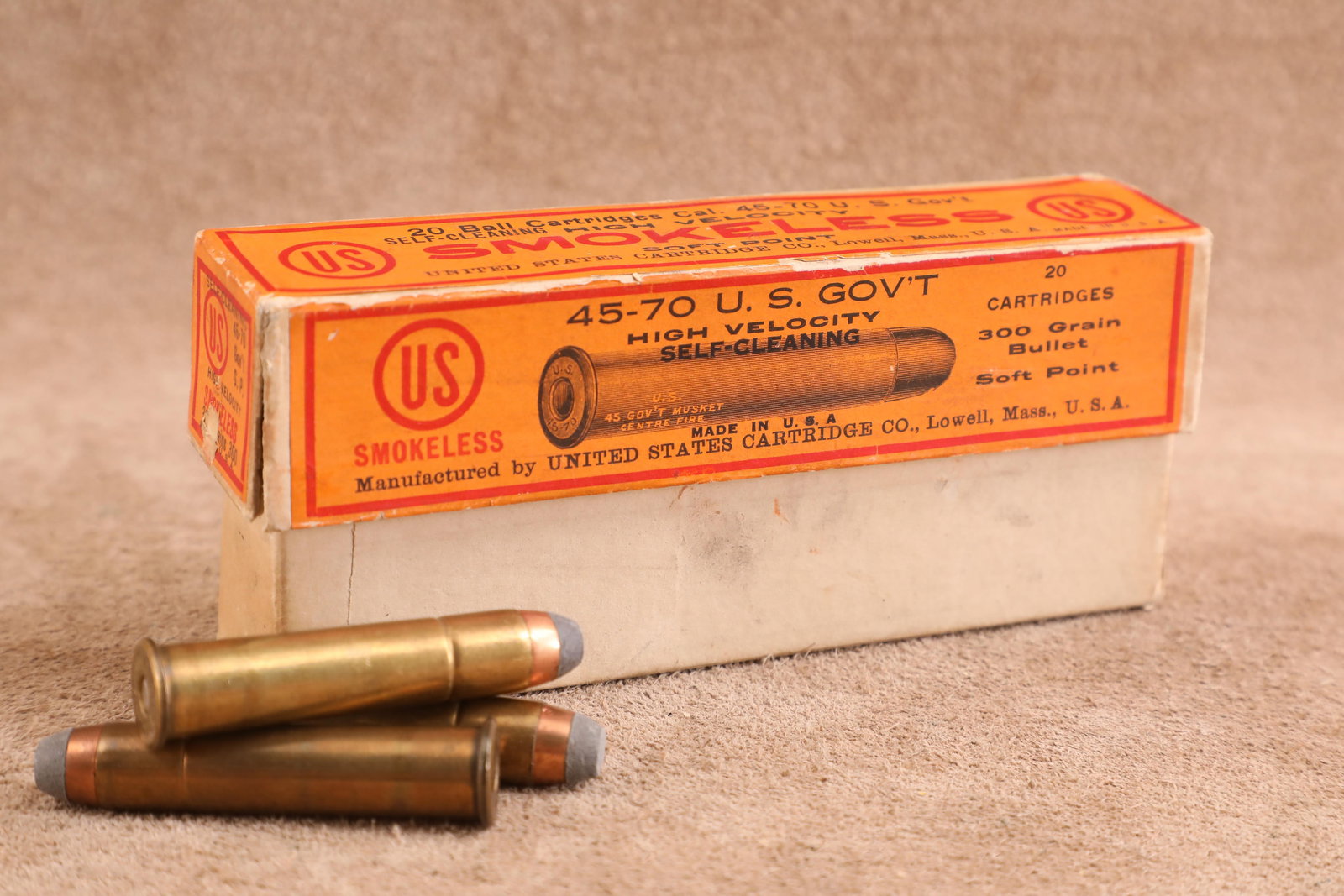 Partial Correct Box, 14 Rounds of Antique 1900s United States Cartridge Co. .45-70 Govt. Ammo: Good Condition. Both front end flaps of the top lid have torn. Some edge tearing, denting, and creasing. Two piece box. Great "SMOKELESS" callout on the oran