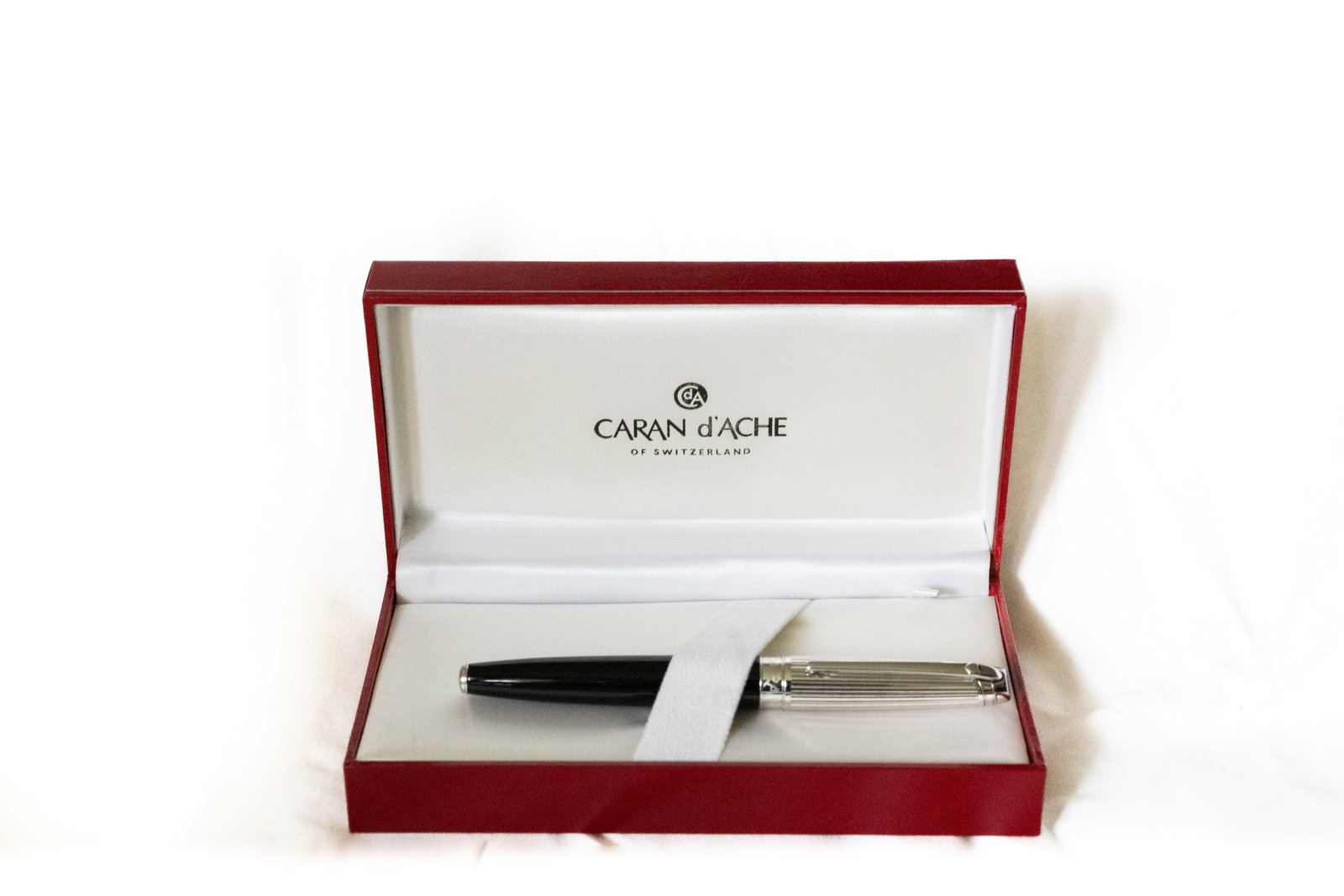 Caran d’Ache Leman Bicolor Black Lined Rhodium Fountain Pen: Caran d’Ache Leman Bicolor black/lined rhodium fountain pen with box, papers and outer box. Black lacquer barrel with rhodium lined cap and medium 18 K 750 nib. Length 5 7/16” and 6 3/8”