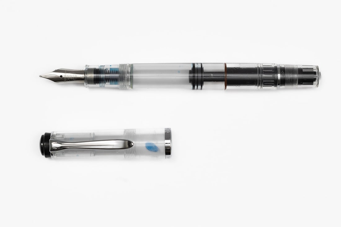 Pelikan M205 Transparent Demonstrator Fountain Pen: Pelikan M205 transparent clear demonstrator fountain pen, with box. Clear demonstrator with black top and fine Pelikan nib. Length 4 7/8” and 5 3/4” posted. Overall excellent condition wit