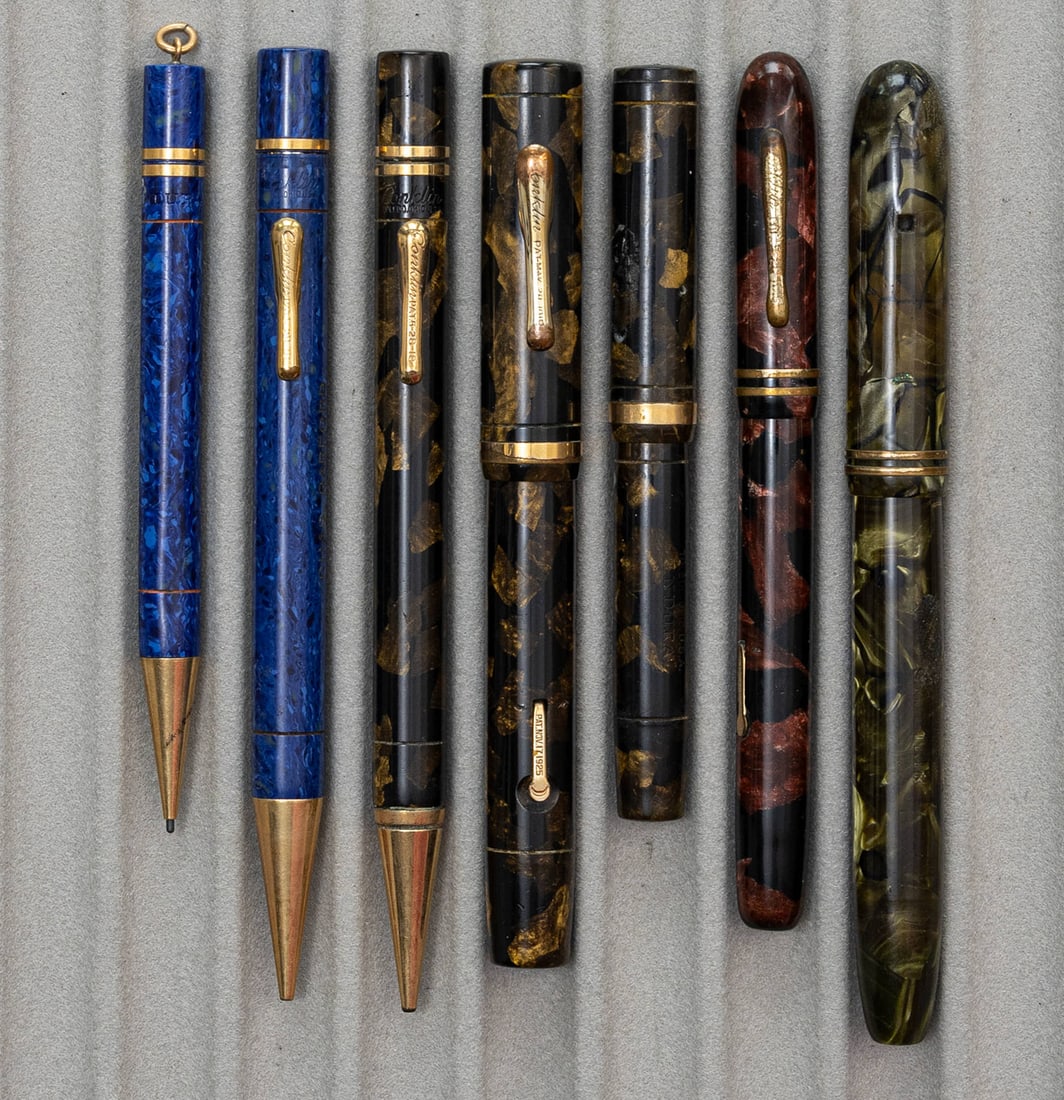 Conklin Fountain Pen & Mechanical Pencil Lot (7): Conklin Endura and Symetrik fountain pen and pencil lot including oversized Endura set (7). All fountain pens with original 14K nibs in good condition, top band and ring missing from smaller black & b
