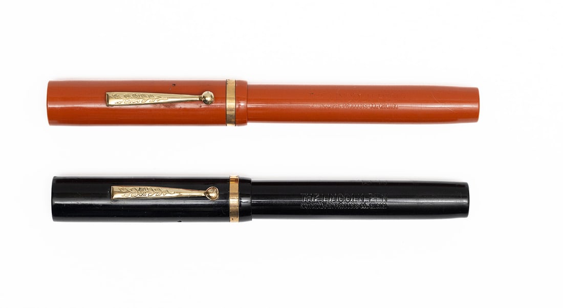 Lincoln Oversized Black & Orange Fountain Pens: Lincoln oversized black and orange flattop fountain pens. Lincoln flattop oversized pens in black and orange, both with warranted 14K nibs. Legible imprints with very slight brassing to edges of trim.