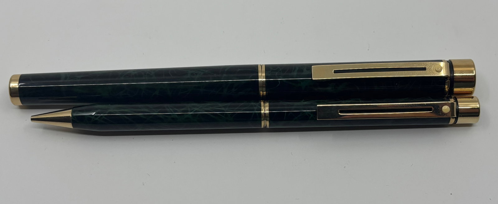Sheaffer Targa Green Ronce Fountain Pen & Pencil Set: Sheaffer Targa Green Ronce fountain pen and pencil set. Black lacquer with green veins with 14K fine Sheaffer nib. Length 5 1/8” (pencil), 5 3/8” (pen), filling mechanism